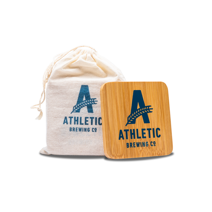 a bag and 1 athletic brewing wooden coaster