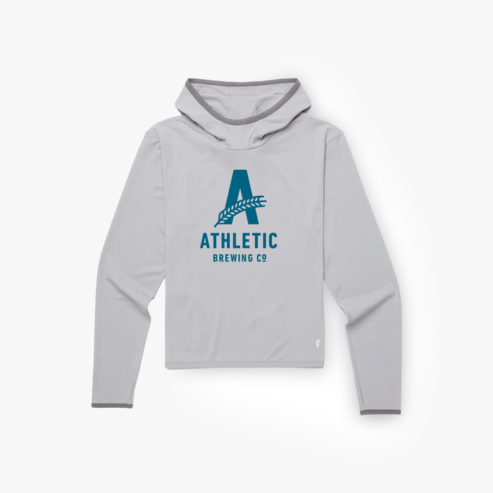 A flat-lay view of a light grey Cotopaxi Sombra hoodie featuring a large dark blue Athletic Brewing Co. "A" logo on the chest.