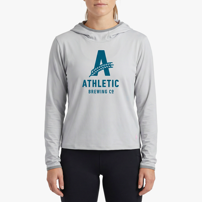 A model wearing the light grey Athletic Brewing Co. x Cotopaxi Sombra sun hoodie.