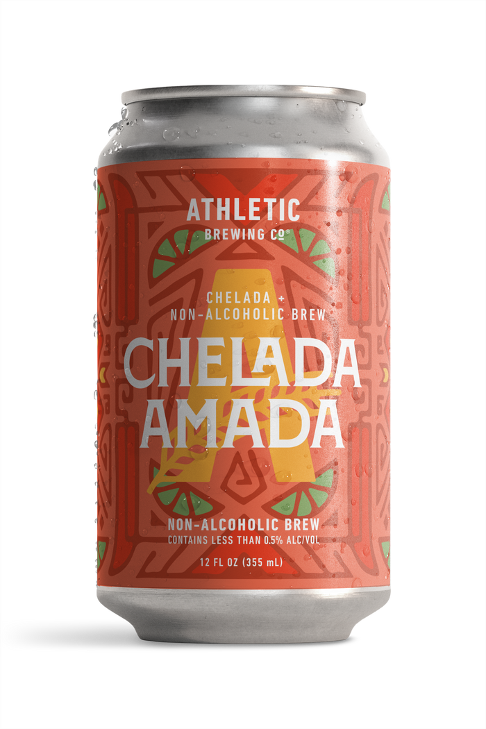 12 fl oz can of Athletic Brewing Chelada Amada non-alcoholic brew on a white background. The can features a coral-red label with a bold geometric pattern, lime slice illustrations, a large gold “A,” and the product name “Chelada Amada” in white lettering. Condensation droplets cover the can, emphasizing a cold, refreshing beverage.