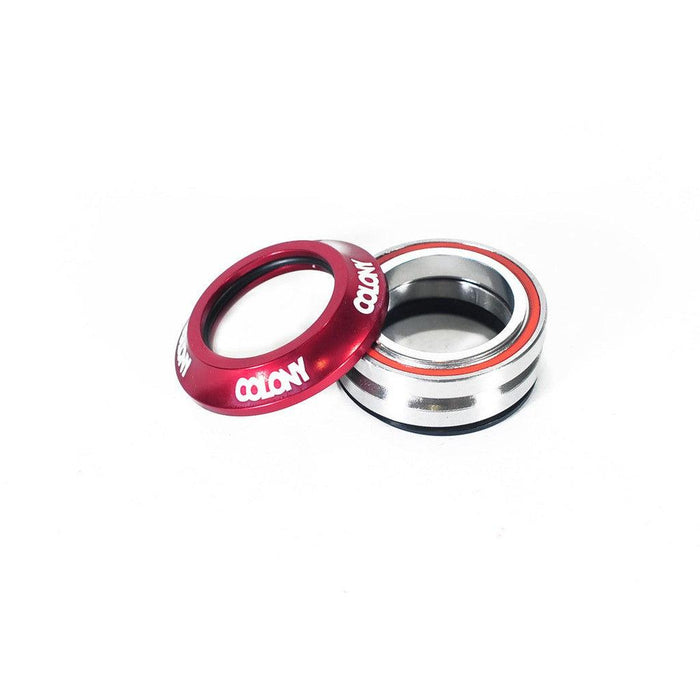Two Colony Integrated Headsets are displayed against a white background; one is a Colony Integrated Headset in red with white text, and the other is silver with black and orange accents, featuring high quality cartridge bearings.