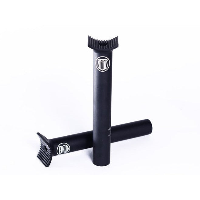 Two black Colony Pivotal Seat Posts (185mm) with grooved tops and white logos are shown, one upright and one lying down, on a white background.
