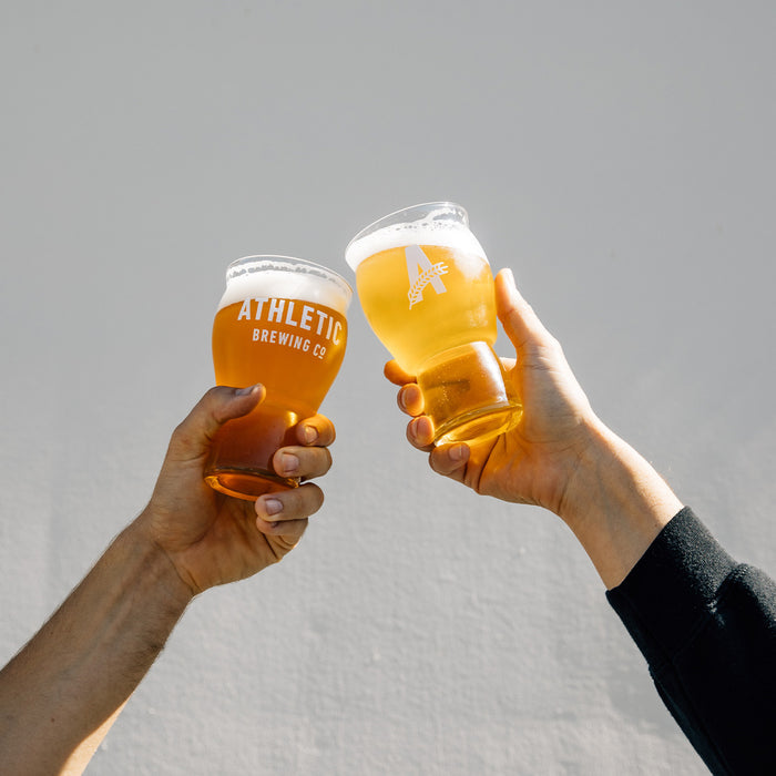 Two friends clinking glasses with beer