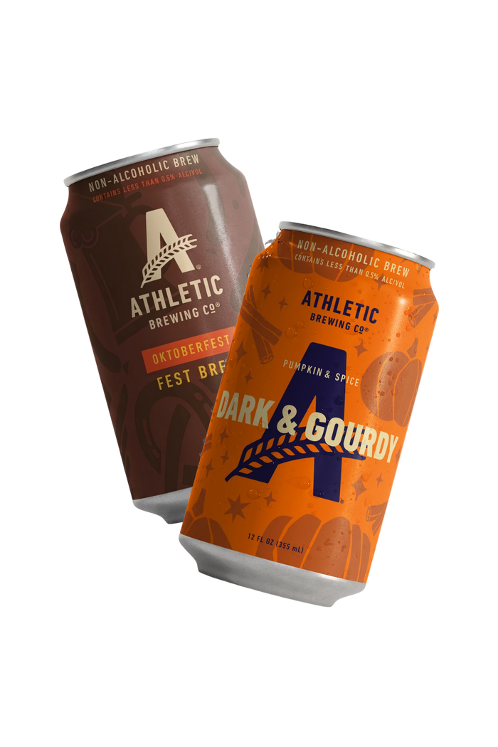 Athletic Brewing Oktoberfest Fest Brew and Dark & Gourdy Pumpkin & Spice non-alcoholic brew cans angled together on a transparent background.