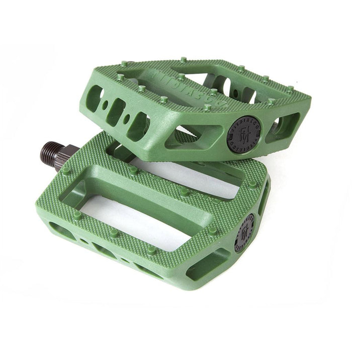 Fit Mac Plastic Pedals are green bike pedals with textured surfaces, a concave shape for grip, and circular black end caps, shown against a white background.