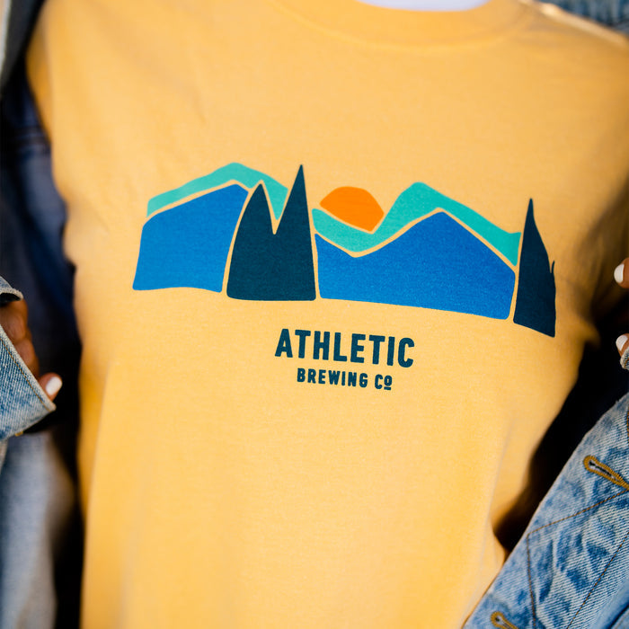 A yellow Athletic brewing co flagship landscape t-shirt close up shot