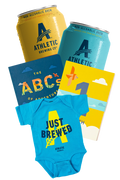 Athletic Brewing Co. products including cans, books, and a baby onesie on a white background
