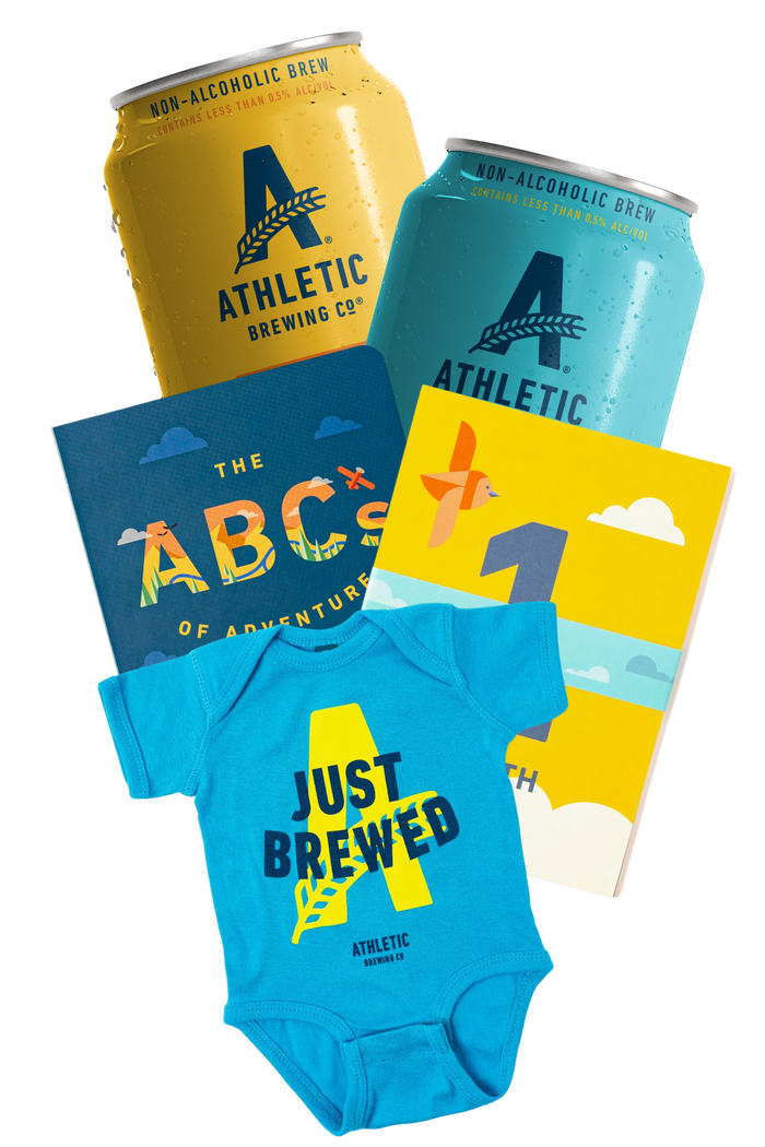 Athletic Brewing Co. products including cans, books, and a baby onesie on a white background