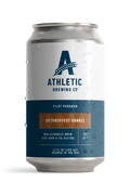 12 fl oz can of Athletic Brewing Oktoberfest Dunkel Pilot Program non-alcoholic brew on a white background. The can features Athletic Brewing's signature white and navy Pilot Program design with a warm brown label decorated with a subtle Bavarian diamond pattern. Condensation droplets cover the can, highlighting the beer's cold, refreshing presentation.