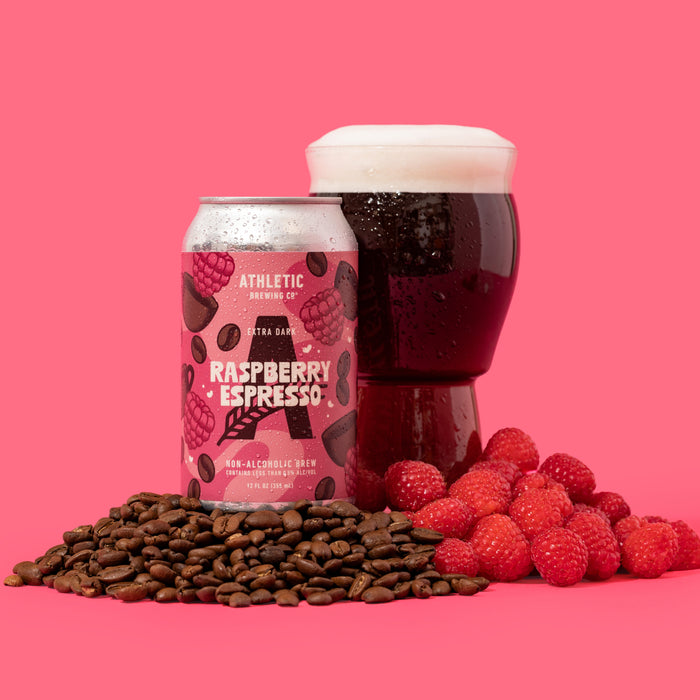 Raspberry espresso can and a glass of the extra dark beer surrounded by coffee and raspberries fruit