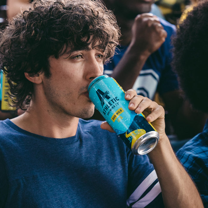 a customer drinking a 19.2oz of run wild in a stadium