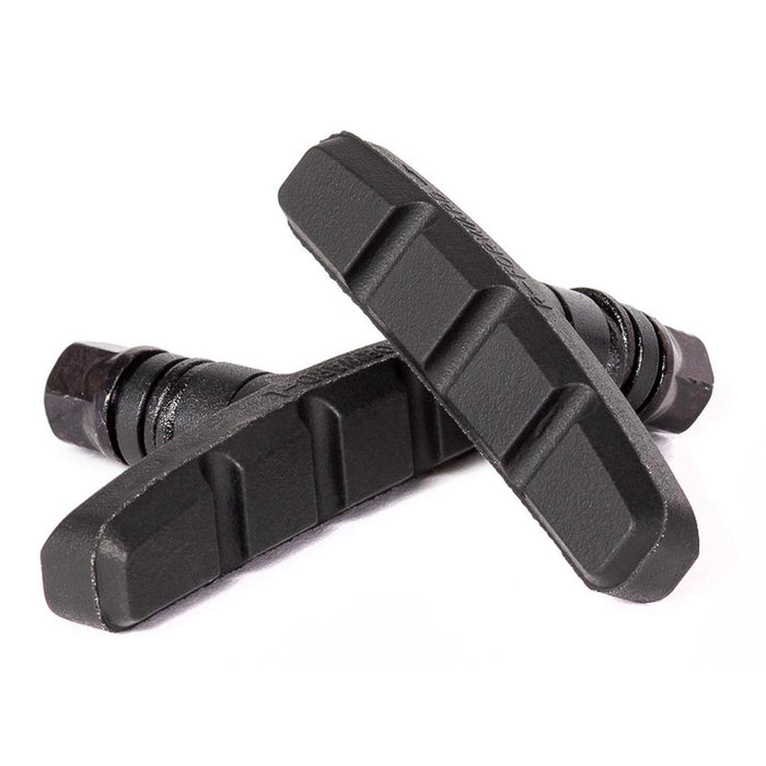 Two Salt AM Brake Shoes, mid-length u-brake pads made from soft black rubber, are positioned opposite each other on a white background.