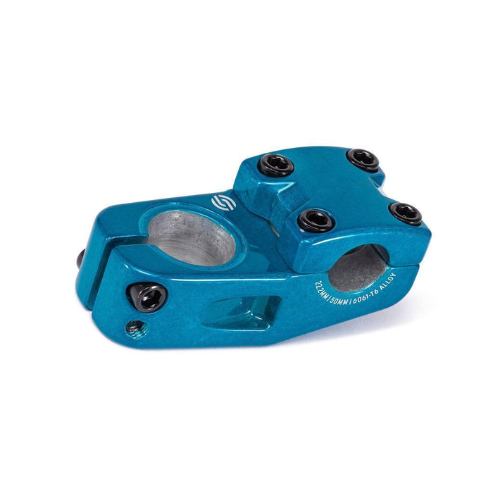 The Salt Am V2 Top Load Stem (22.2mm Clamp) is a blue anodized BMX bike stem crafted from durable 6061 T6 alloy, featuring four black bolts on top, two on the side, and shark tooth clamping for enhanced grip. This stem displays precise machining details and proudly showcases the Salt logo.