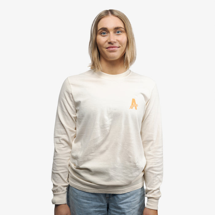 a happy woman wearing Athletic brewing co, tan long sleeve t-shirt