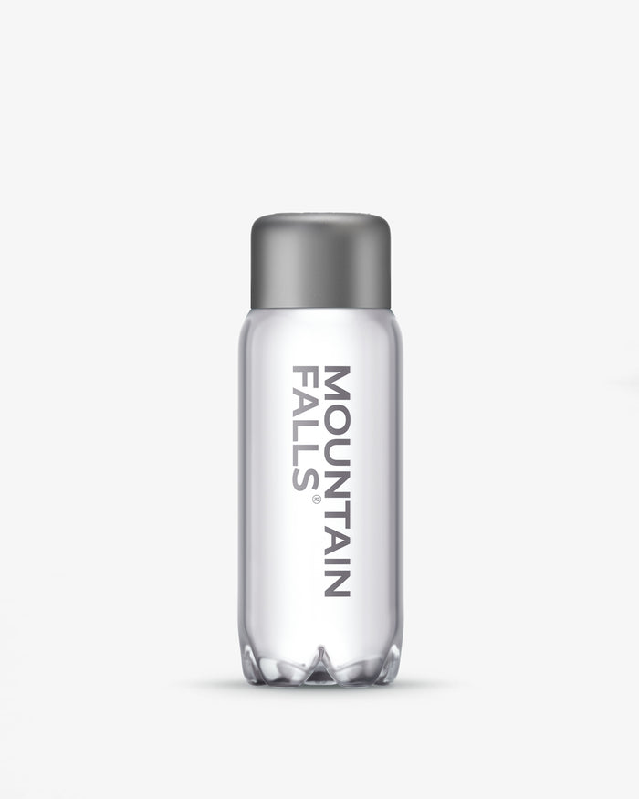 A 330ml sparkling mineral water bottle with the brand name Mountain Falls visible on the label.