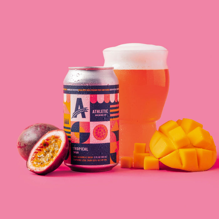 a can of tropical sour and a glass showcasing the liquid with mango and passionfruit on the side